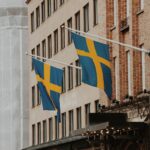 a couple of flags hanging from the side of a building