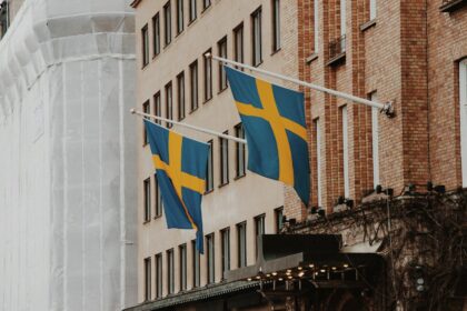 a couple of flags hanging from the side of a building
